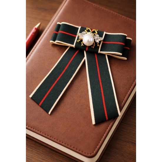 Elegancka broszka w formie kokardy z dekoracyjną perłą – stylowy dodatek inspirowany klasyczną elegancją z wyrazistym charakterem.